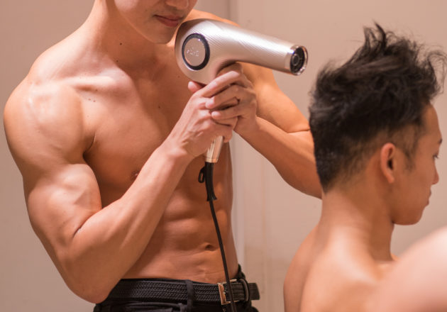 ドライヤーに集中するアシスタントマッチョ(縦写真)/reference stock photo muscle beauty salon blow dryer@写真　マッチョ