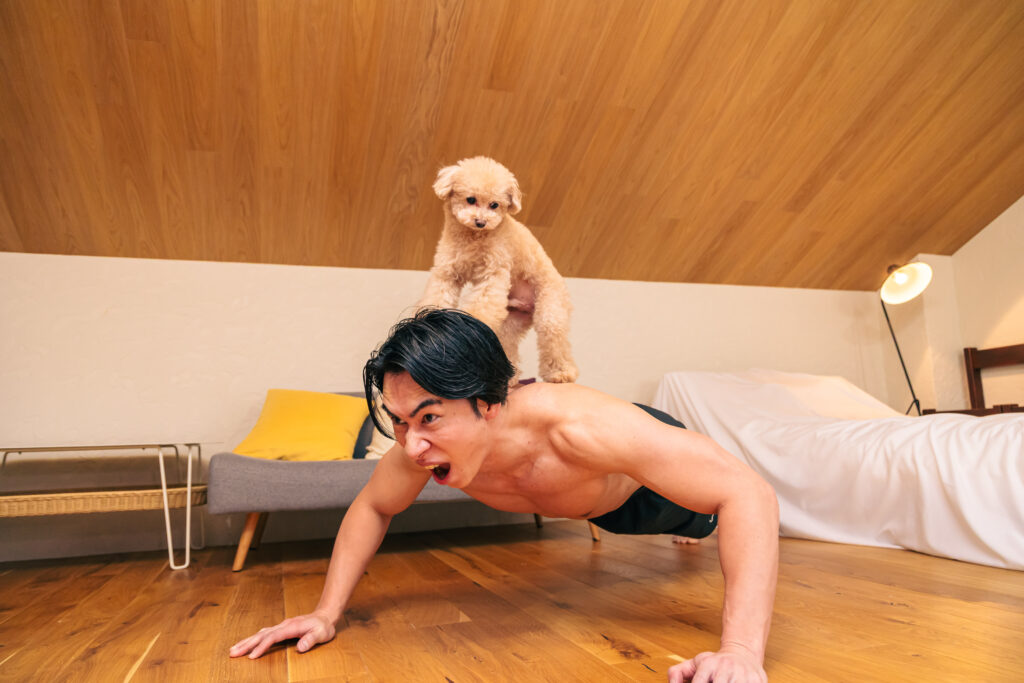 犬に筋トレで追い込まれるマッチョ@フリー素材　犬